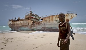 A masked pirate stands by a washed up Taiwanese fishing vessel in the once-bustling pirate den of Hobyo, Somalia. The crew were released after a ransom was paid. Photograph: Farah Abdi Warsameh/AP