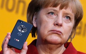 Merkel holds her mobile used for governmental communication during her opening tour at the CeBit computer fair in Hanover (REUTERS/Fabrizio Bensch)